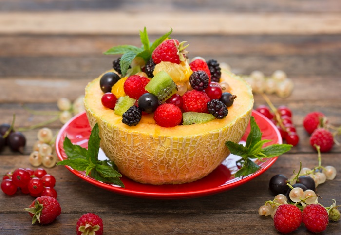 Fruit salad in a melon bowl with berries