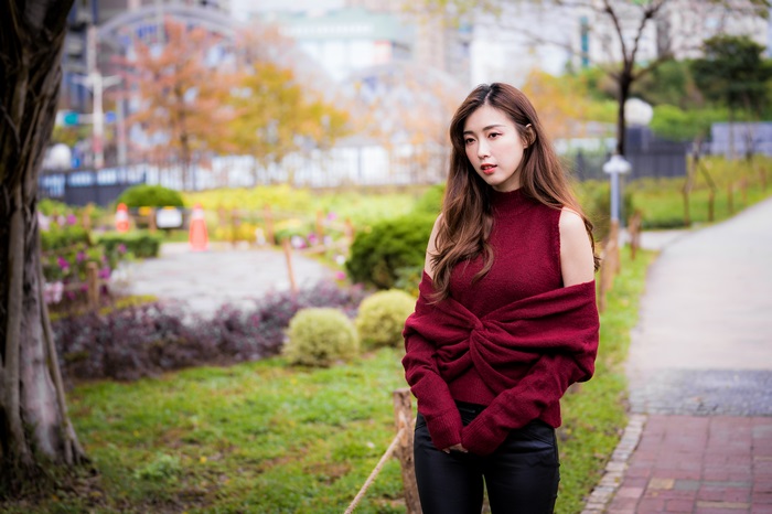 Asian woman with long brown hair wearing a maroon sweater