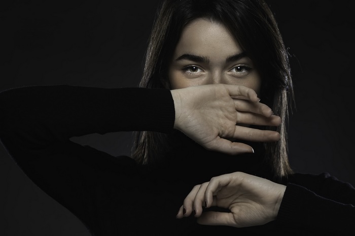 Brunette woman covering her mouth with hands
