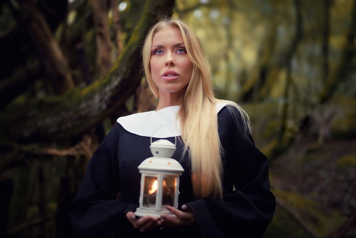 Woman in nun costume holding a lantern