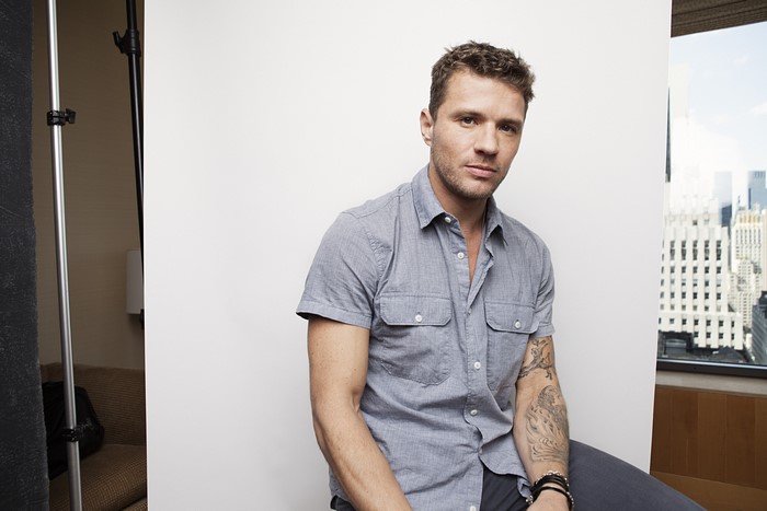 Ryan Phillippe sitting in front of a white backdrop