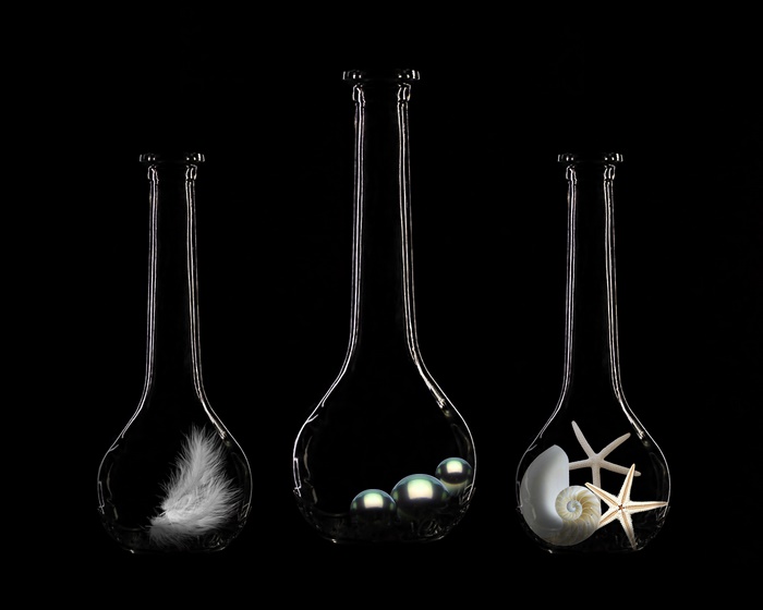 Glass flasks with feather, pearls, and seashells