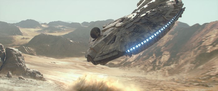 Millennium Falcon flying over desert landscape
