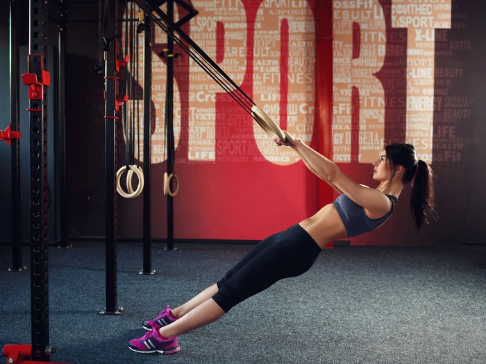 Woman exercising with gymnastic rings in a gym