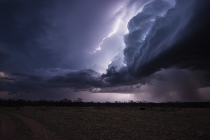 Lightning strikes a stormy sky over a field