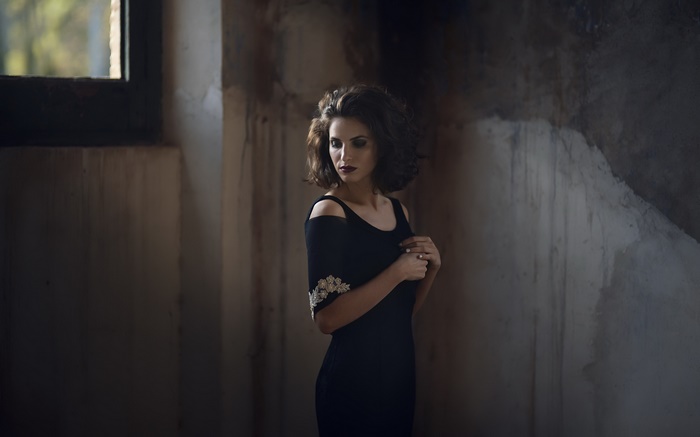 Woman in black dress in a derelict room