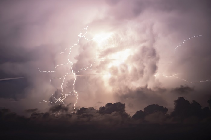 Lightning striking through dark storm clouds