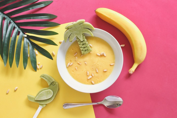 Yellow soup with banana and palm tree decoration