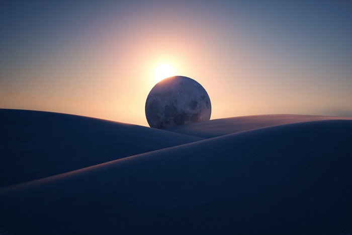 Moon over desert dunes at sunset