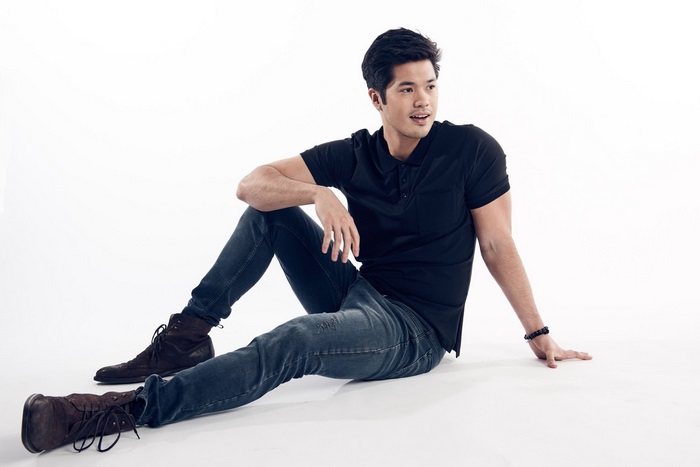 Ross Butler sitting on white background