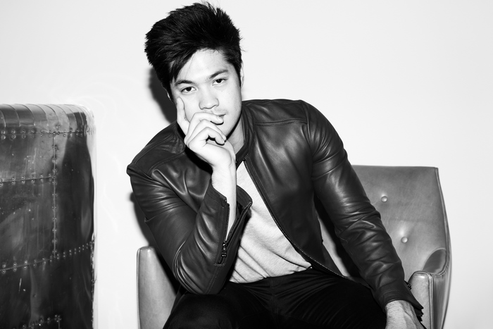 Ross Butler sitting in a chair