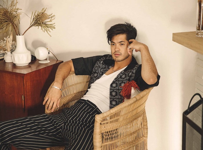 Ross Butler sitting in a chair