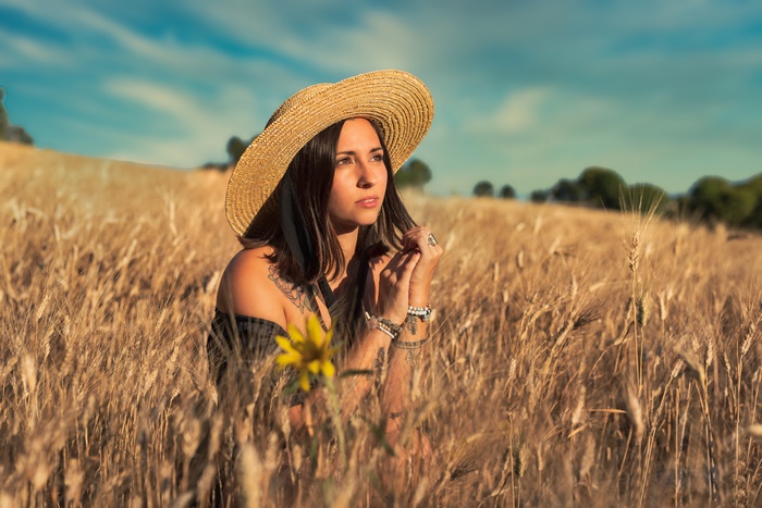 Woman in straw hat in a wheat field