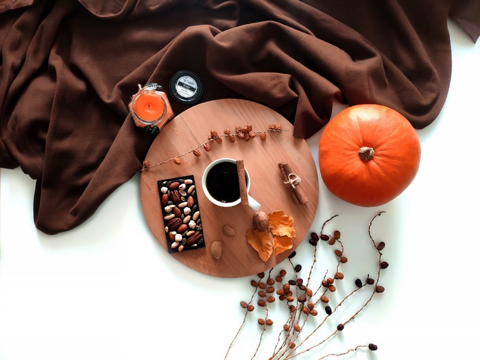 Autumn still life with pumpkin, coffee, chocolate, and candle