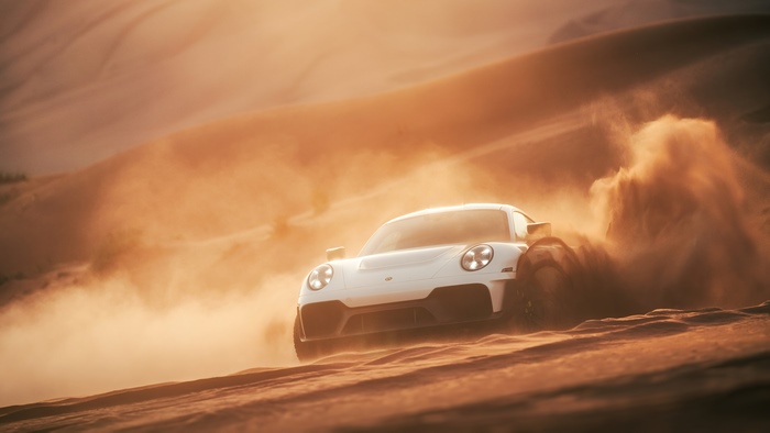 White Porsche 911 GT3 RS driving through desert sand dunes