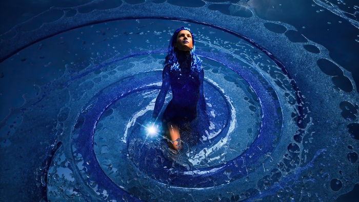 Woman in blue standing in a water vortex