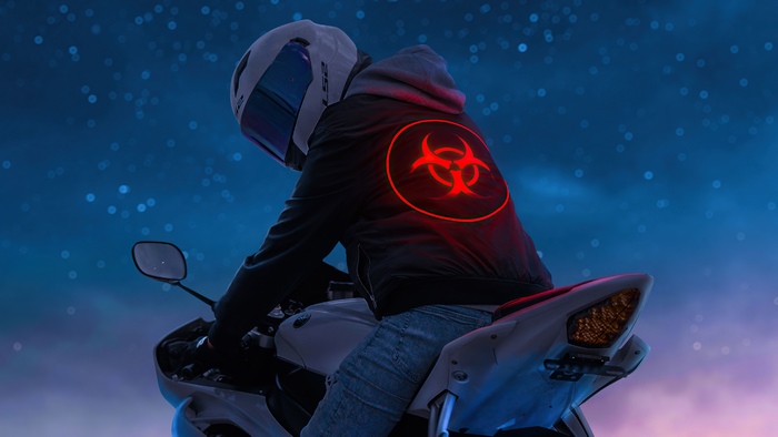 Biker with biohazard symbol on jacket on motorcycle at night