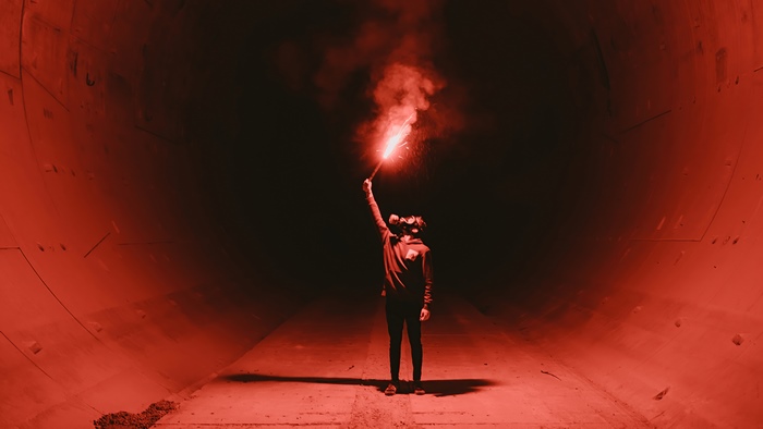 Person with flare in tunnel