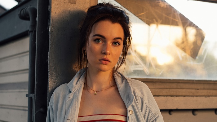 Young woman leaning against a wall