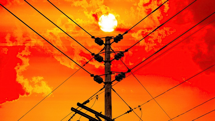 Sun behind power lines and clouds