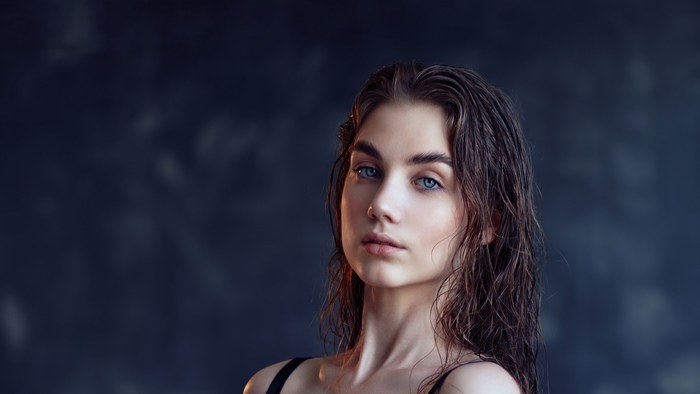 Portrait of a young woman with wet hair and blue eyes
