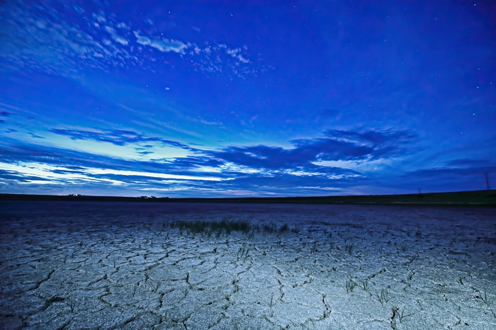Cracked earth under a starry night sky