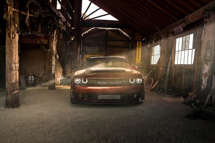 Red Dodge Challenger in a rustic barn