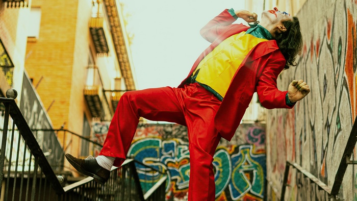 Joker in red suit dancing on stairs