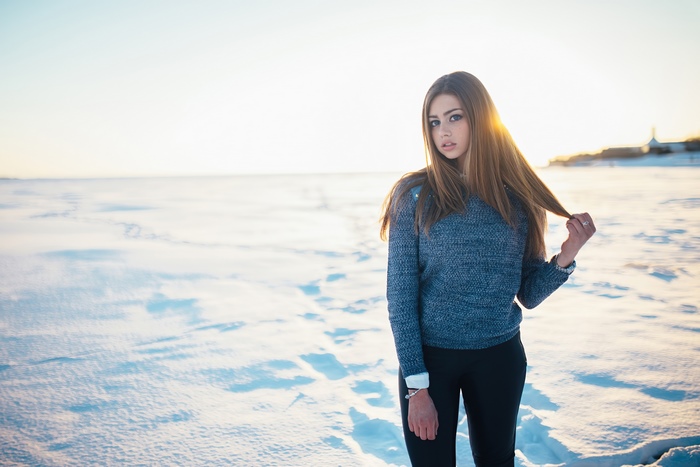 Girl in a sweater in a snowy field