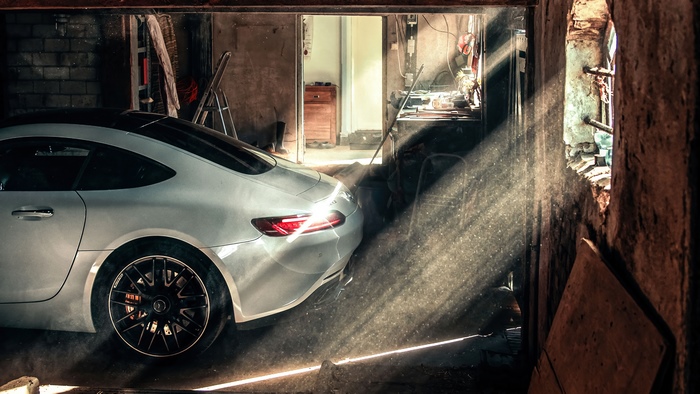 White Mercedes-AMG in a dusty garage with sunbeams