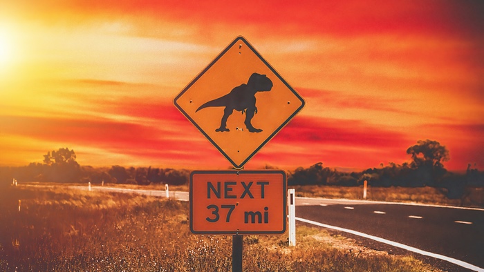 Dinosaur warning sign on a road