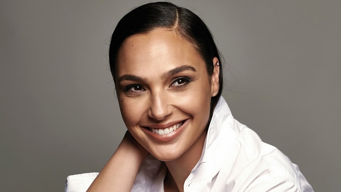 Gal Gadot smiling in a white shirt
