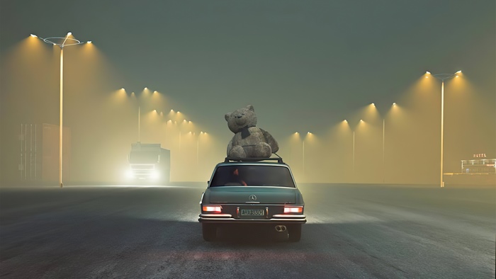 Teddy bear on car roof in foggy industrial area