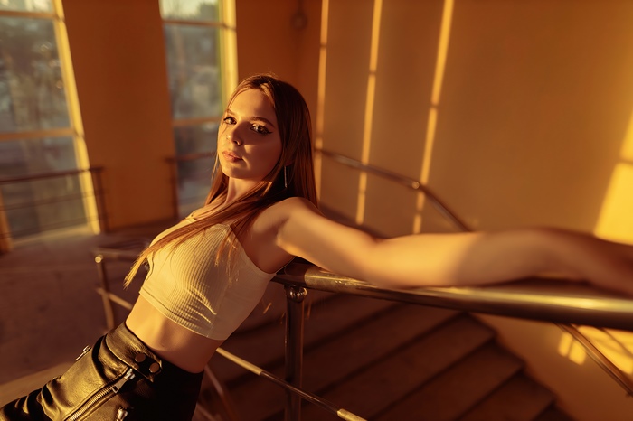 Model posing on a staircase with golden hour lighting
