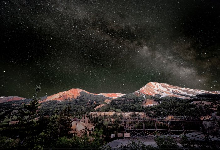 Milky Way over Red Mountains and Wooden Structure