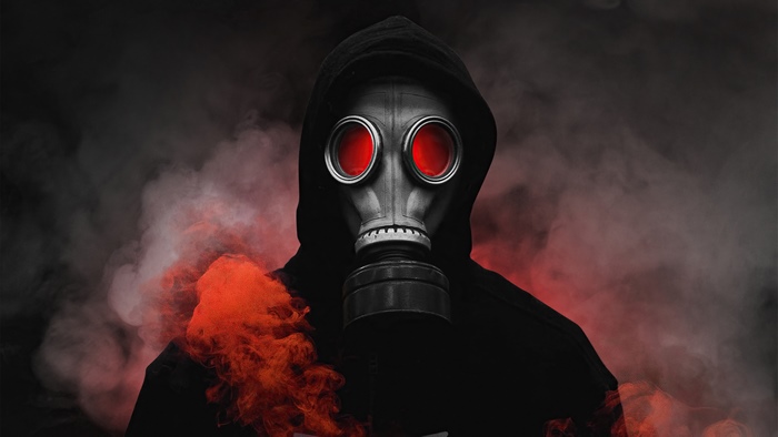 Person in gas mask with red eyes and smoke