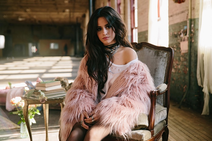 Camila Cabello sitting in a chair