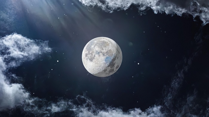 Full moon in a cloudy night sky