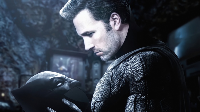 Batman holding a Batman mask