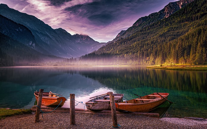 Boats on a misty mountain lake at sunrise