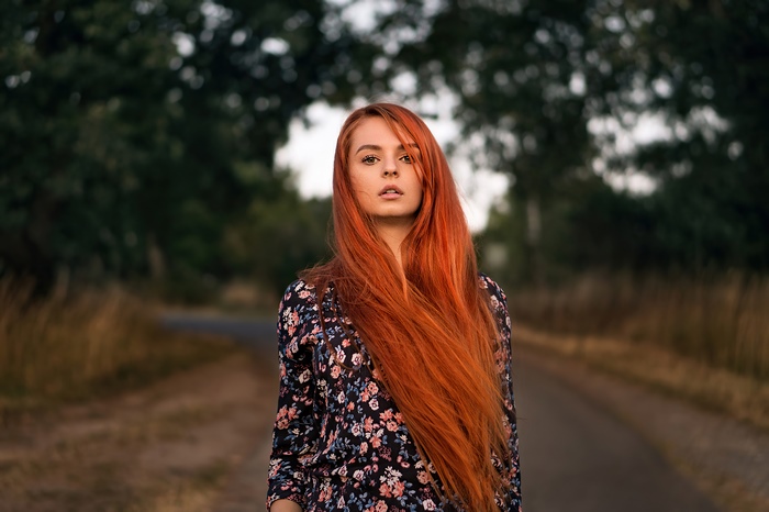 Redhead girl in floral dress on a road