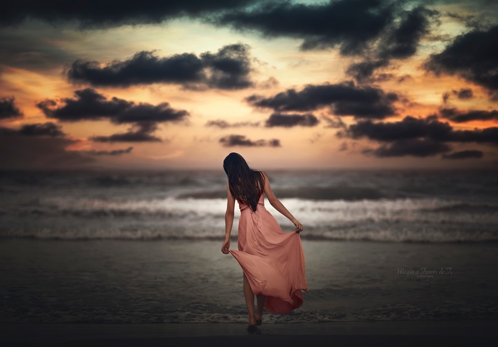 Girl in dress on beach at sunset