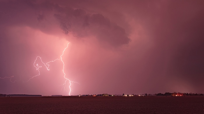 Lightning strike over a field at night