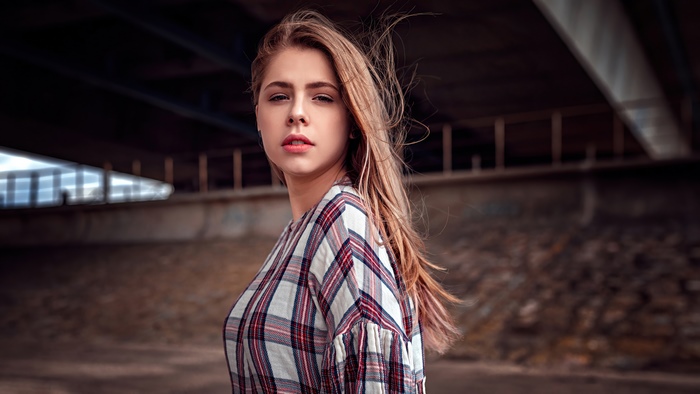 Model in plaid shirt under bridge