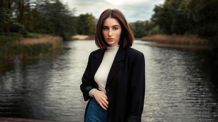 Model in black blazer and white turtleneck by water