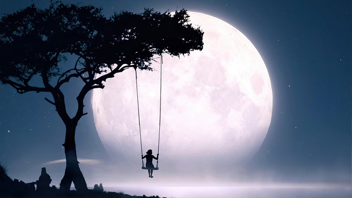 Silhouette of a girl on a swing in front of a giant moon