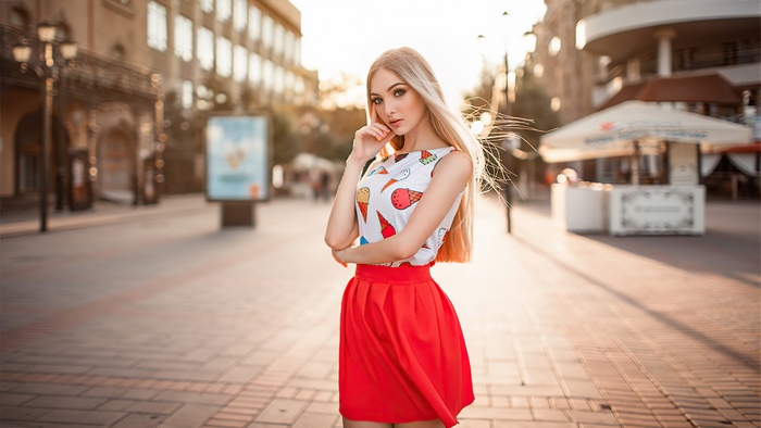 Blonde model in ice cream print top and red skirt