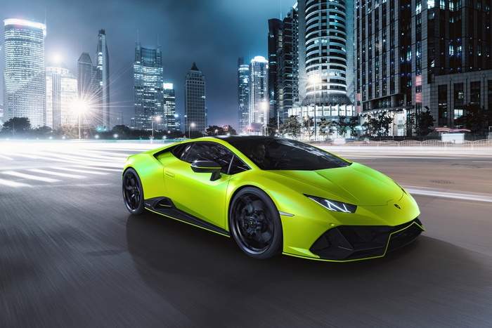 Lime green Lamborghini Huracan driving in city at night