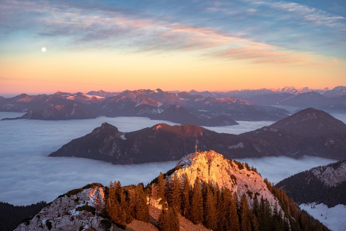 Mountain range with fog and moon at sunrise