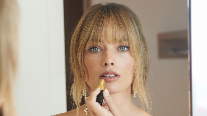 Margot Robbie applying lipstick